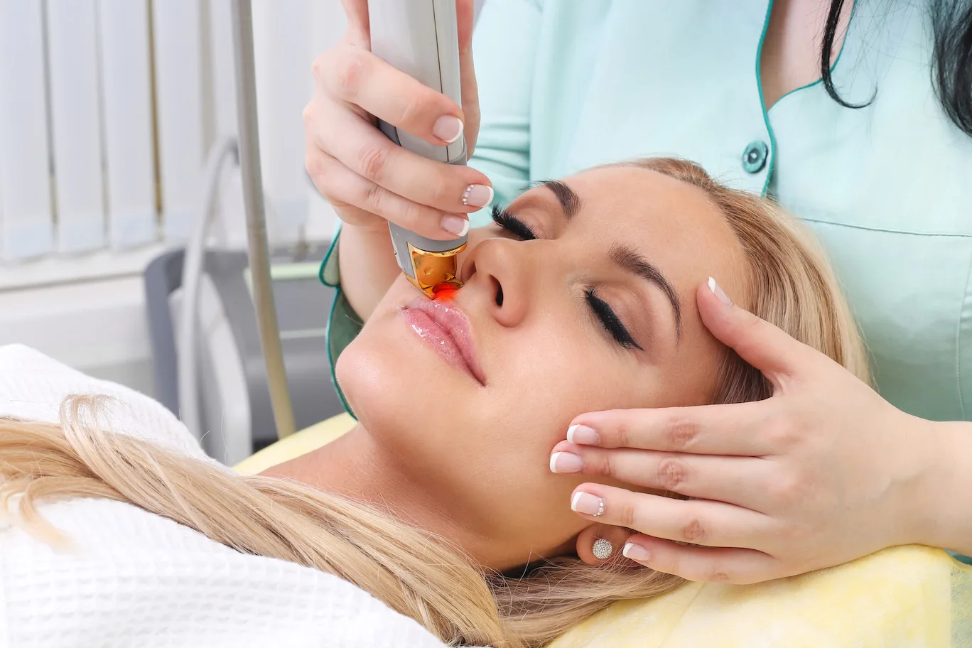 Close up of a blonde woman getting laser hair removal on her upper lip.